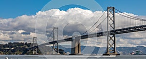 Panorama of the San Francisco bay bridge with fluffy white clouds