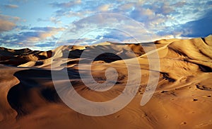 Panorama of sand dunes Sahara Desert at sunset. Endless dunes of yellow sand. Desert landscape Waves sand nature
