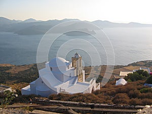 Traditional orthodox white church on sunset to Milo in the Cyclade Islands in Greece. photo