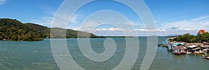 Panorama seascape view of old wooden house and fishing boat in community.