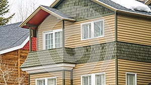 Panorama Selective focus of townhome with balcony and snowy roof against cloudy sky