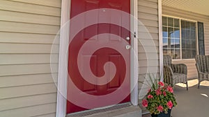 Panorama Shiny red wooden front door of a home with wicker chairs on the sunlit porch