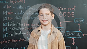 Panorama shot of caucasian boy smiling and standing at blackboard. Erudition.
