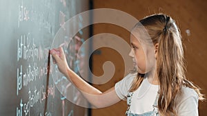 Panorama shot of smart girl writing engineering prompt on blackboard. Erudition.