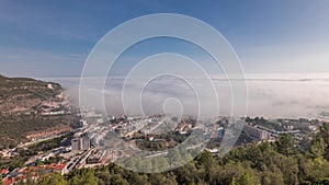 Panorama showing aerial View of Sesimbra Town and Port covered by fog timelapse, Portugal.