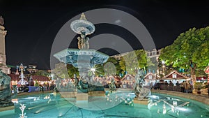 Panorama showing illuminated fountain with holiday decorations at the Rossio Christmas Market timelapse on Dom Pedro IV