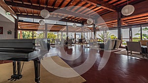 Panorama showing Interior of a modern hotel cafe bar restaurant with piano and fireplace timelapse