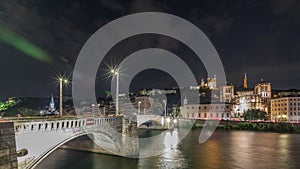 Panorama showing night timelapse of Lyon's cityscape with the red suspension footbridge over the Saone River. France photo