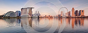 Panorama of Singapore city skyline at business modern downtown building area in sunrise with cloud and sun light and reflection