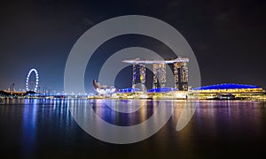 Panorama of Singapore city skyline with Marina Bay Sands hotel and ArtScience Museum at night.