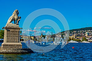 Panorama of Siwss town Zuerich behind a lion statue and Springbr photo