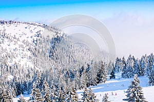 Panorama of ski resort Kopaonik, Serbia, people skiing, houses covered with snow