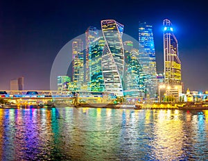 Panorama of Skyscrapers of Moscow City with reflections in Moscow river at night.