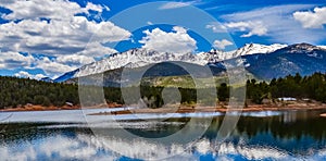 Panorama Snow-capped and forested mountains near a mountain lake, Pikes Peak Mountains in Colorado Spring, Colorado, US