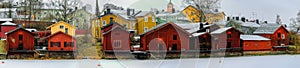 Panorama of snow covered embankment in the old part of the city Porvoo on a overcast winter day. Empire-style homes painted in