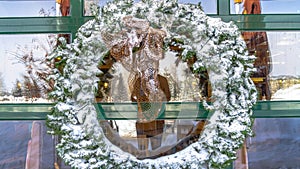 Panorama Snowy leafy wreath hanging on the glass wall of a building in Wasatch Mountains