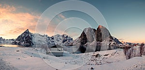 Panorama of snowy mountain with fishing village at sunset