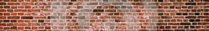 Panorama of a soiled dirty red brick wall. Old dilapidated brick wall surface