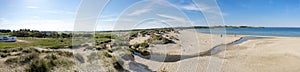 Panorama of Sola beach, sand dunes and a small river entering the sea