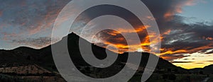 Panorama of a Spanish desert and mountain landscape with a colorful and expressive sunset sky