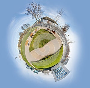 panorama of Spreebogen park in Berlin with government buildings in Berlin in early morning light in tiny planet format