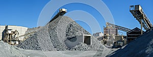 Panorama of stone crushing and screening plant with piles of gravel and machinery