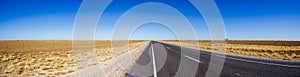 Panorama of straight road through the dessert of Australia on the Flinders Hightway, Quennsland Australia