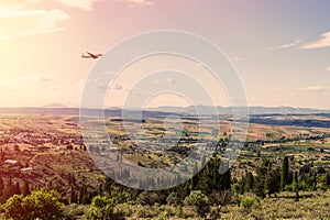 Panorama of the suburbs of the Greek city of Athens with landing plane at sunset