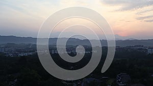 Panorama of sun rising from behind horizon with mountains.