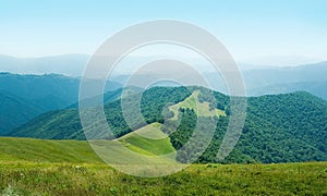 Panorama with sunny day on top of green Carpathian mountains range with blue sky, empty landscape background