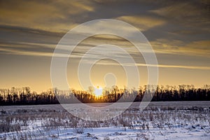 Panorama of the sunrise. Sunrise over the forest belt in front of a snow-covered field in winter, Ulyanovsk Russia