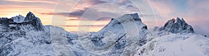 Panorama of sunrise over snowy mountain range with colorful sky in winter on Segla Mount at Senja Island