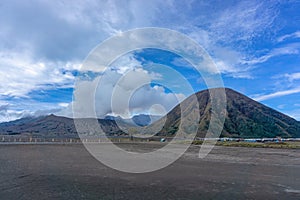 Panorama sunrise view of Mount Bromo, still active volcano and part of the Tengger massif with mist and cloud from vocalno crater.