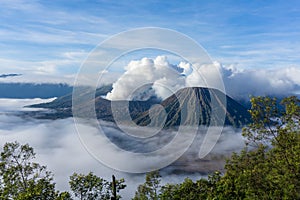 Panorama sunrise view of Mount Bromo, still active volcano and part of the Tengger massif with mist and cloud from vocalno crater.