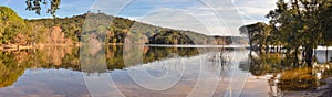 Panorama of a sunset at a lake with crystal clear waters.