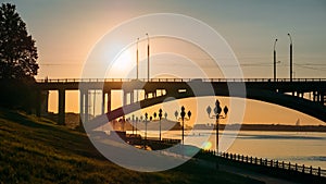 Panorama of sunset over river, modern bridge and city embankment, beautiful urban evening landscape