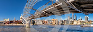 Panorama of the Thames river with Millennium bridge and Saint Paul`s Cathedral and the City skyline in the background.