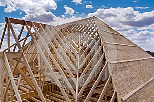 Panorama top view of closeup new wooden roof beams built home under construction under framing