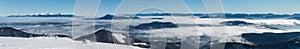 Panoráma z vrcholu zimného horského hrebeňa nad nízkou oblačnosťou