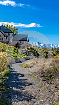 Panorama Trail along houses in front of a lake with grassy shore viewed on a sunny day