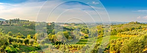 Panorama of the Tuscan valley at sunset, many guest villas on the hills