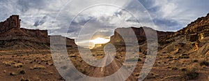 Panorama of a two track dirt road heading into the sunset of Canyonlands National Park