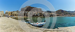 A panorama view across the old harbour of Cefalu, Sicily with the mesa and mountains as a backdrop