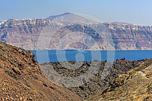 A panorama view across the volcanic island of Nea Kameni, Santorini with Mount Taygetus and the caldera in the background