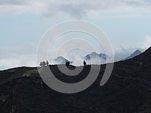 Panorama view of andean volcano caldera crater lake Quilotoa isolated trees on rim ridge loop in Cotopaxi Ecuador andes