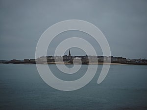 Panorama view of atlantic coast walled city historical old town of Saint Malo at blue hour from Dinard Brittany France