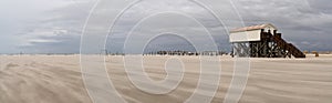 Panorama view of beachfront buildings on stilts on the Wadden Sea coast of northwest Germany