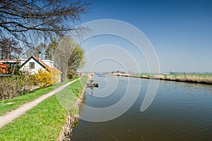 Panorama view with blue sky above a typical Dutch polder and dyke house photo