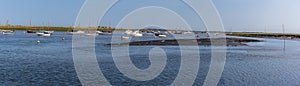 A panorama view of boats moored in Brancaster Bay near Burnham, Norfolk, UK