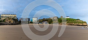 A panorama view from the Castle beach across Castle Hill and South Beach at low tide in Tenby, Wales